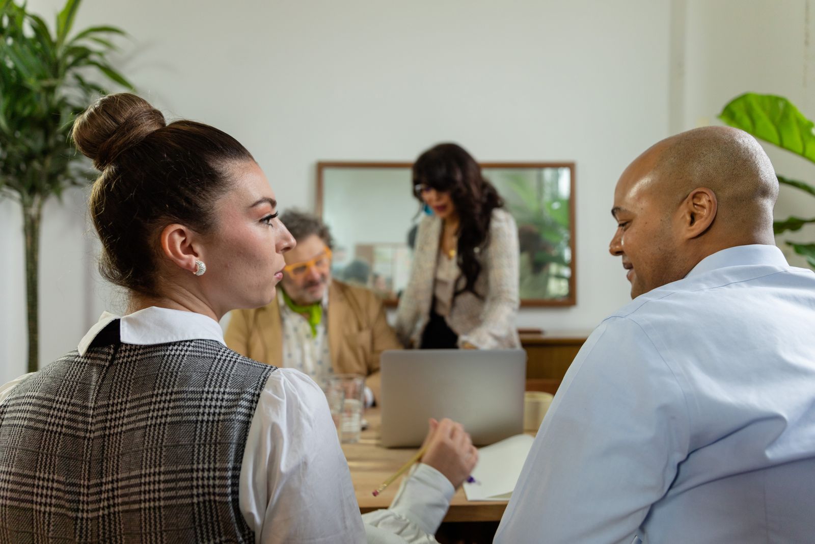 Deux femmes et deux hommes échangent autour d’une table de réunion