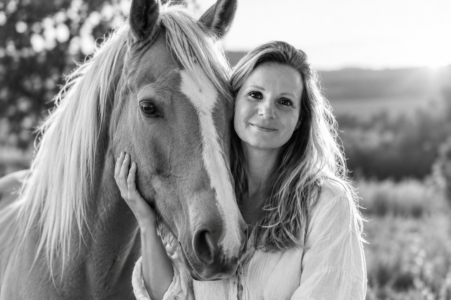 Portrait en noir et blanc d’Amélie Gauthier aux côtés d’un cheval